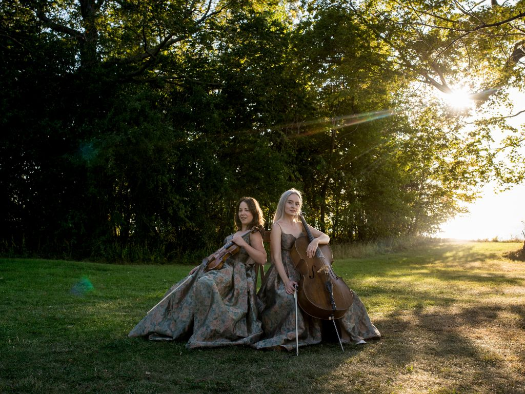 County Strings holding their instruments in the sunset at Sandbanks