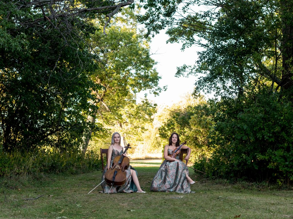County strings sitting with their instruments at Sandbanks Provincial Park in Prince Edward County